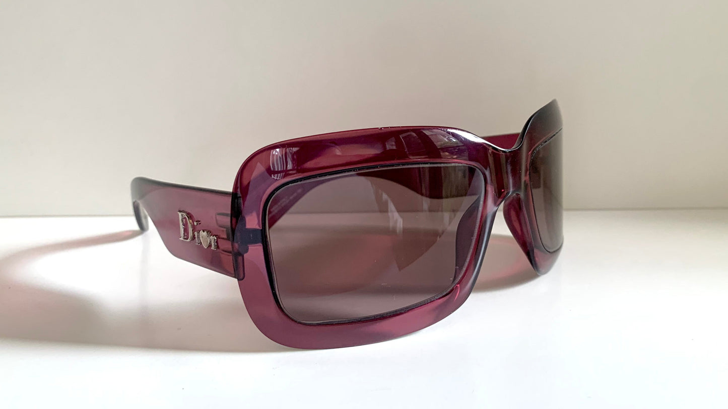 Dior sunglasses with a pink frame and dark lenses on a white background