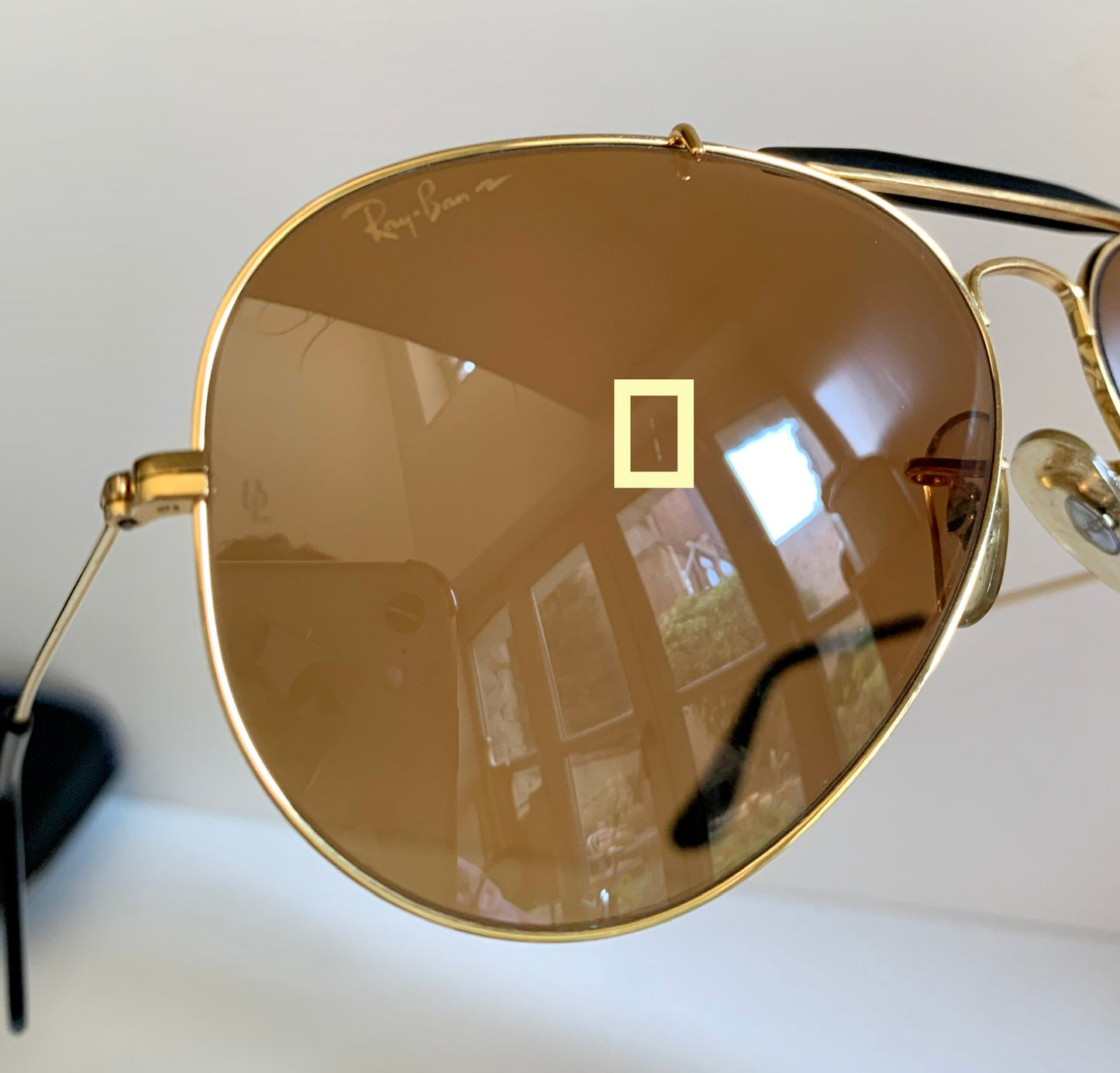 Ray Ban Chromax outdoorsman Gold-framed sunglasses with golden lenses on a white background
