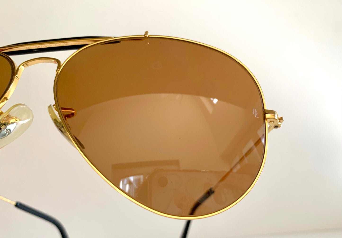Ray Ban Chromax outdoorsman Gold-framed sunglasses with golden lenses on a white background