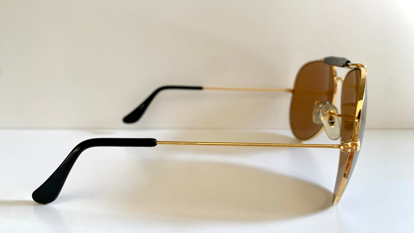 Ray Ban Chromax outdoorsman Gold-framed sunglasses with golden lenses on a white background