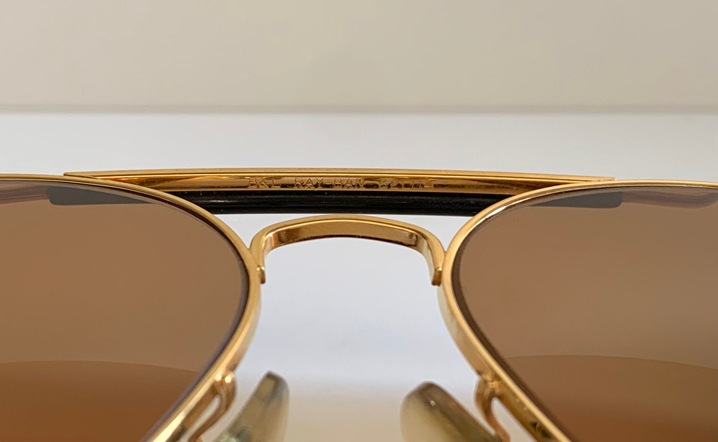 Ray Ban Chromax outdoorsman Gold-framed sunglasses with golden lenses on a white background