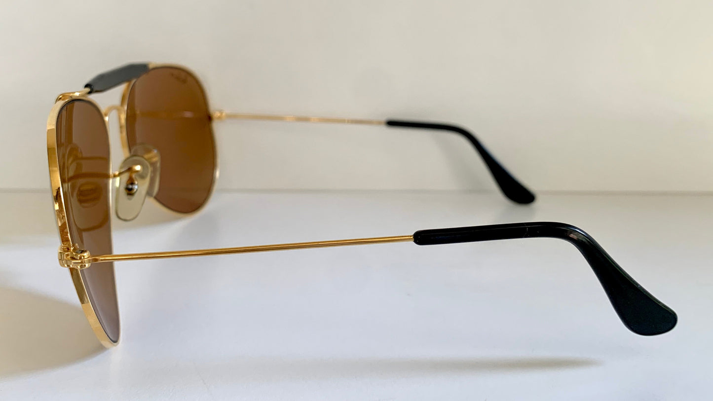 Ray Ban Chromax outdoorsman Gold-framed sunglasses with golden lenses on a white background