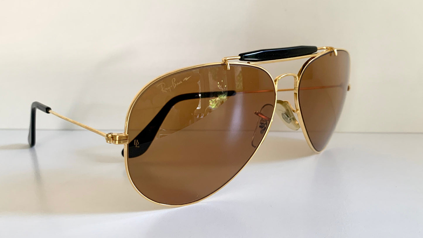 Ray Ban Chromax outdoorsman Gold-framed sunglasses with golden lenses on a white background