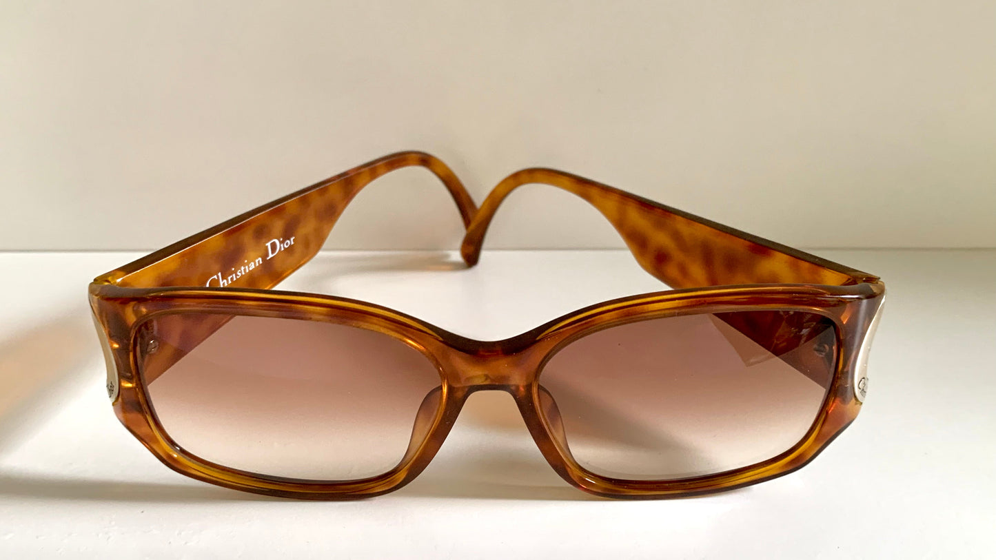 Brown sunglasses with a Dior logo on a white background