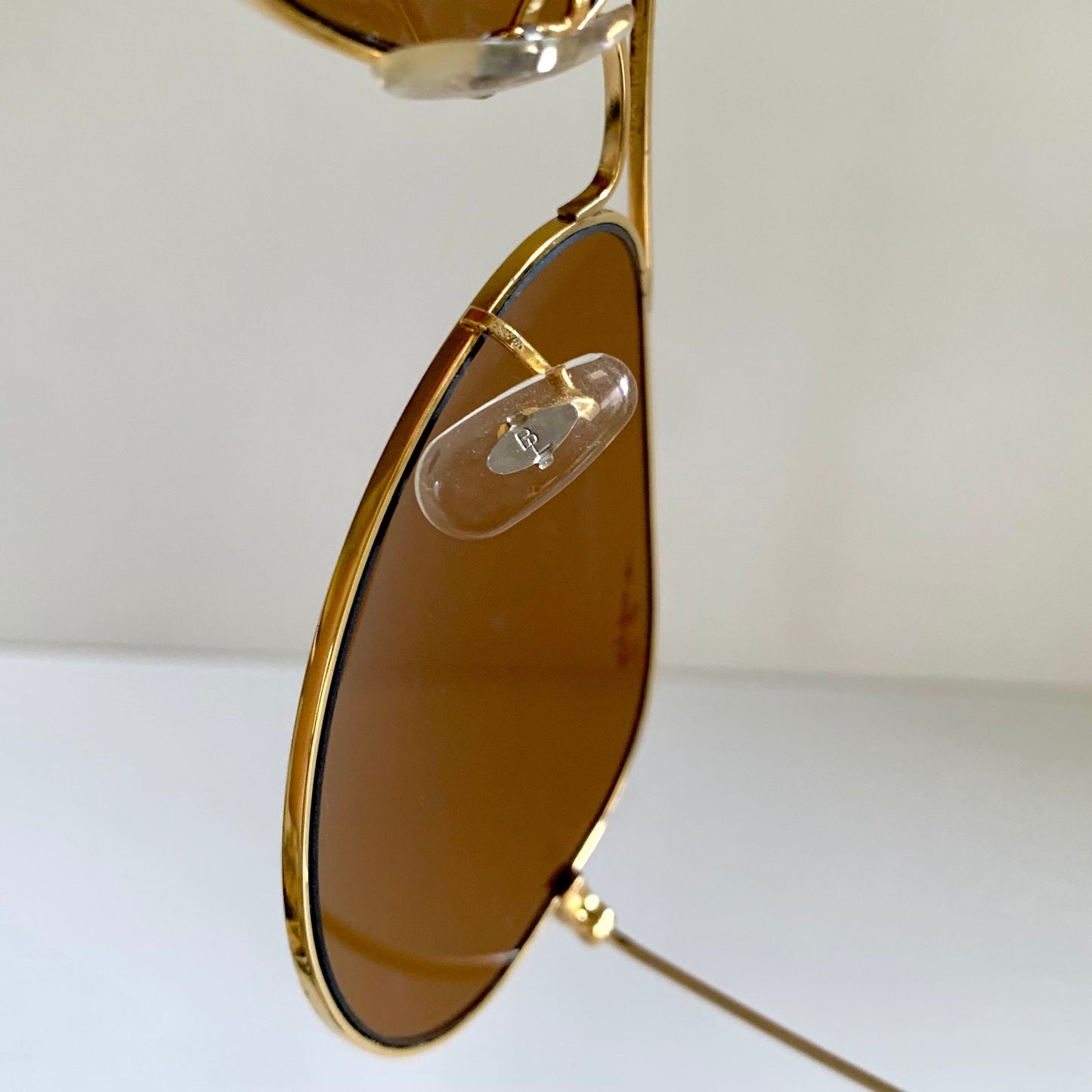 Ray Ban Chromax Gold-framed sunglasses with brown lenses on a white background