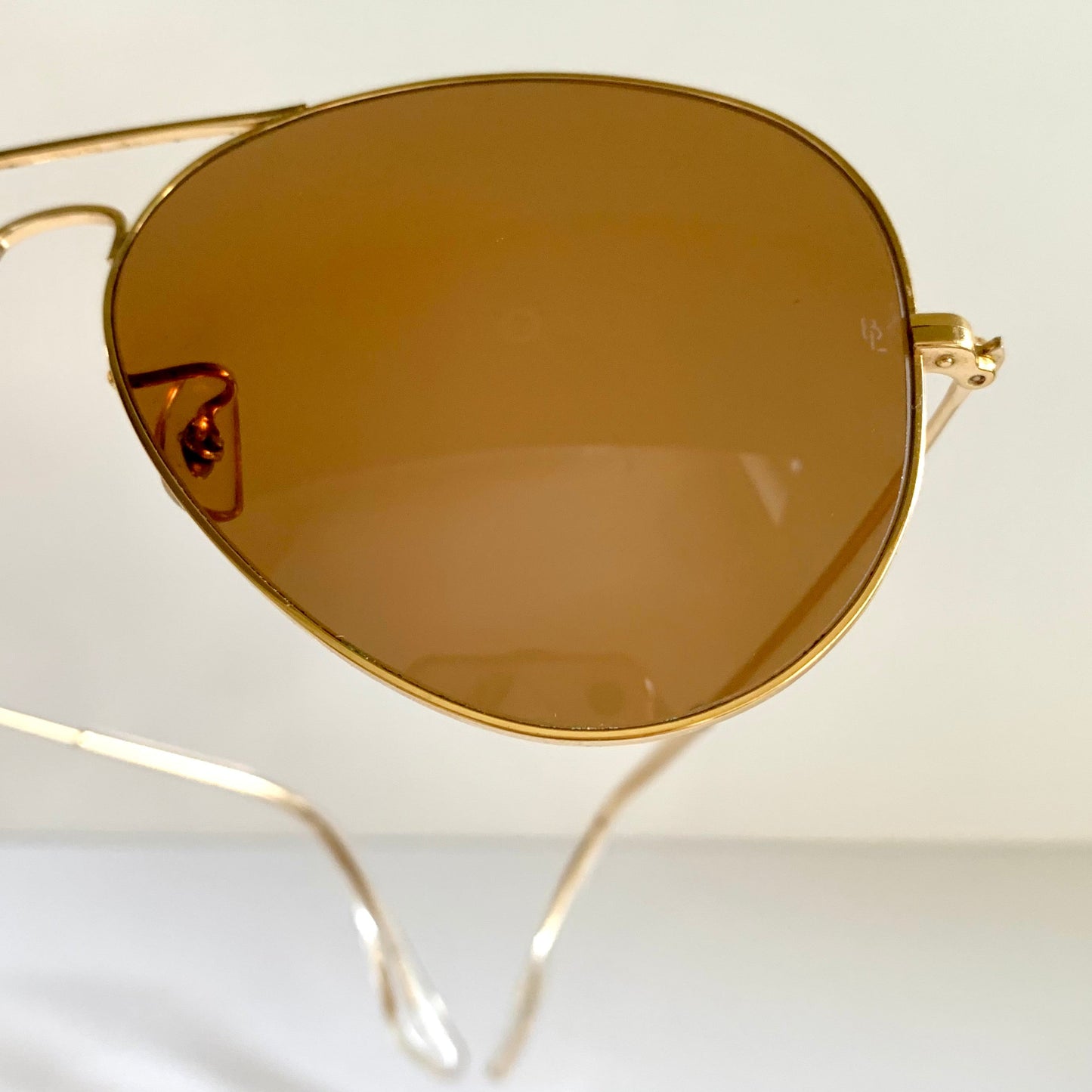 Ray Ban Chromax Gold-framed sunglasses with brown lenses on a white background