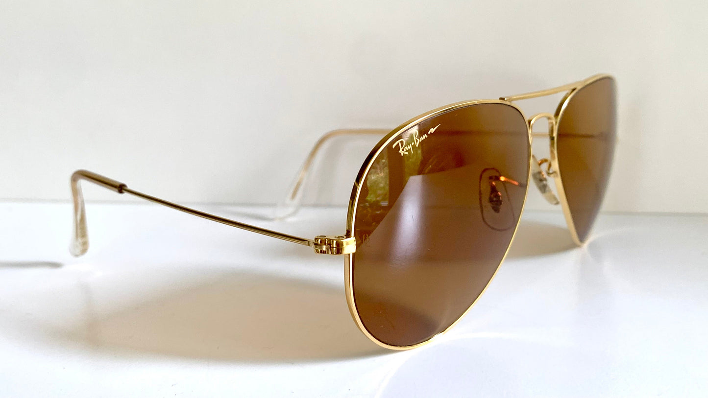 Ray Ban Chromax Gold-framed sunglasses with brown lenses on a white background