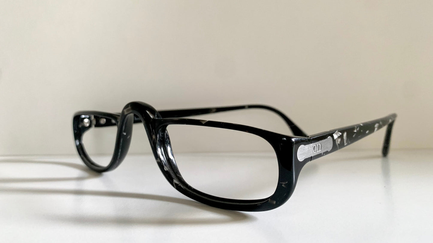 Black eyeglasses on a white surface with a light gray background