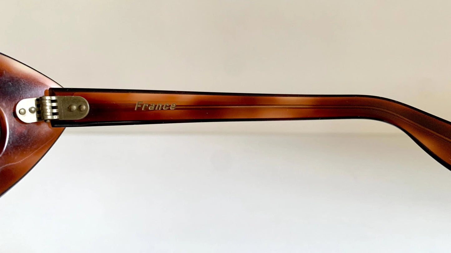 Brown sunglasses with tortoiseshell pattern on a beige background