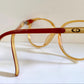 Vintage eyeglasses with yellow frame and red accents on a white background