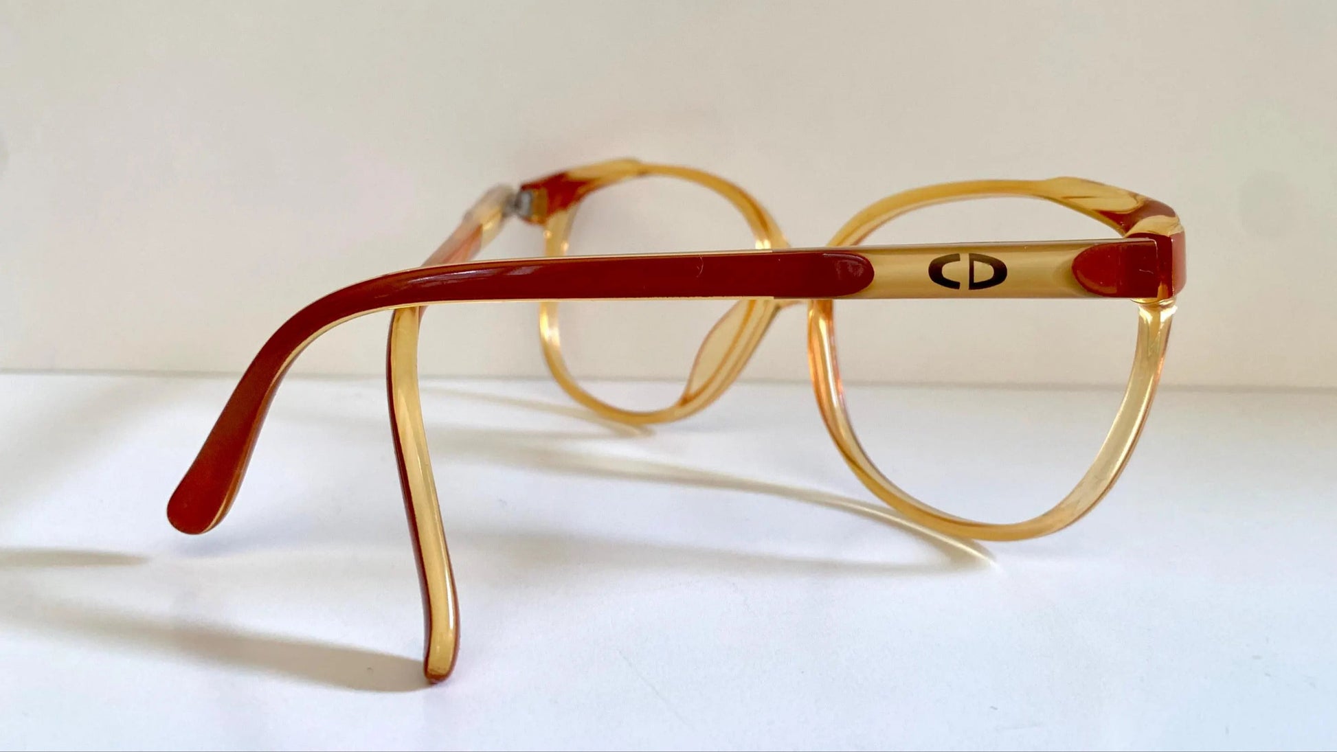Vintage eyeglasses with yellow frame and red accents on a white background
