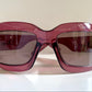 Dior sunglasses with a pink frame and dark lenses on a white background