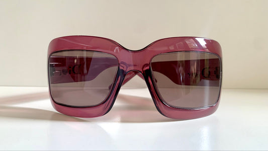 Dior sunglasses with a pink frame and dark lenses on a white background