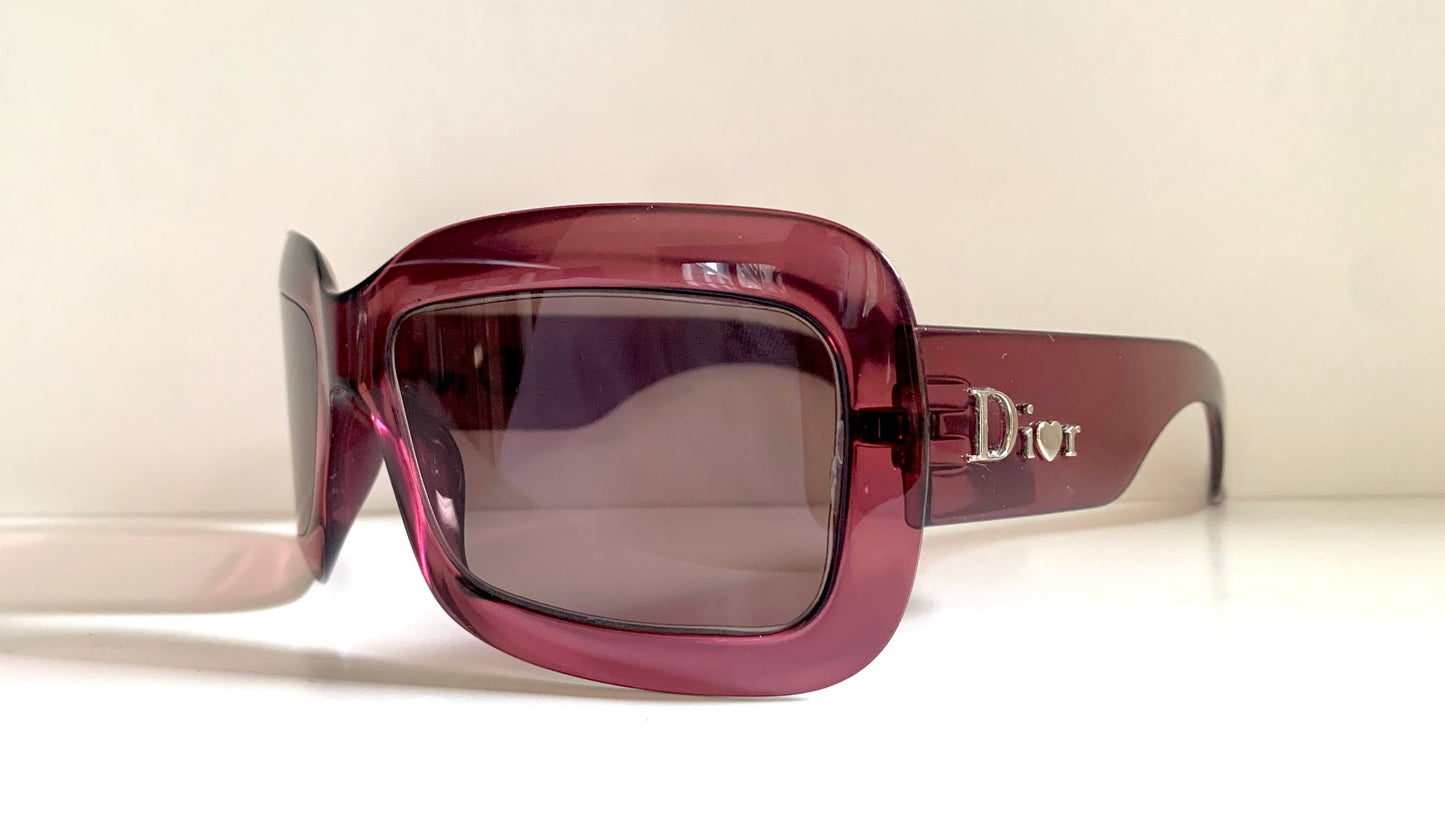 Dior sunglasses with a pink frame and dark lenses on a white background
