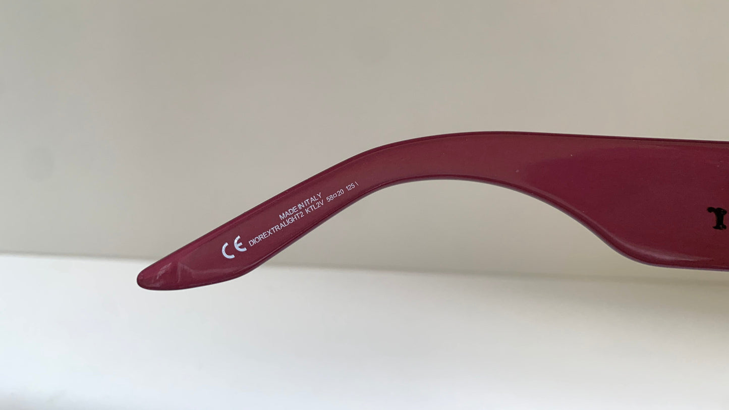 Dior sunglasses with a pink frame and dark lenses on a white background