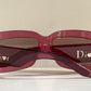 Dior sunglasses with a pink frame and dark lenses on a white background