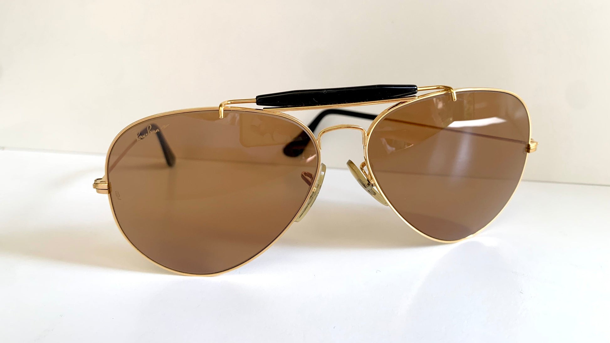 Ray Ban Chromax outdoorsman Gold-framed sunglasses with golden lenses on a white background