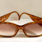 Brown sunglasses with a Dior logo on a white background
