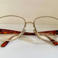 Vintage-style eyeglasses with tortoiseshell arms on a white background