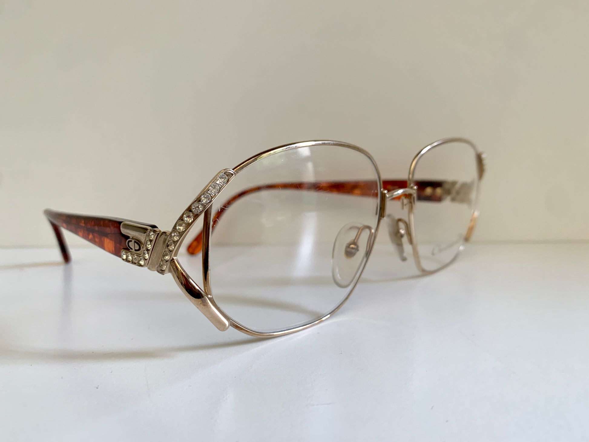 Silver-rimmed eyeglasses with decorative details on a white surface