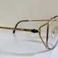 Eyeglasses with a gold frame on a white surface