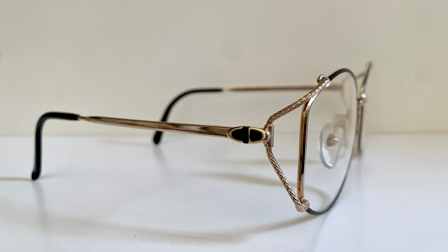 Eyeglasses with a gold frame on a white surface
