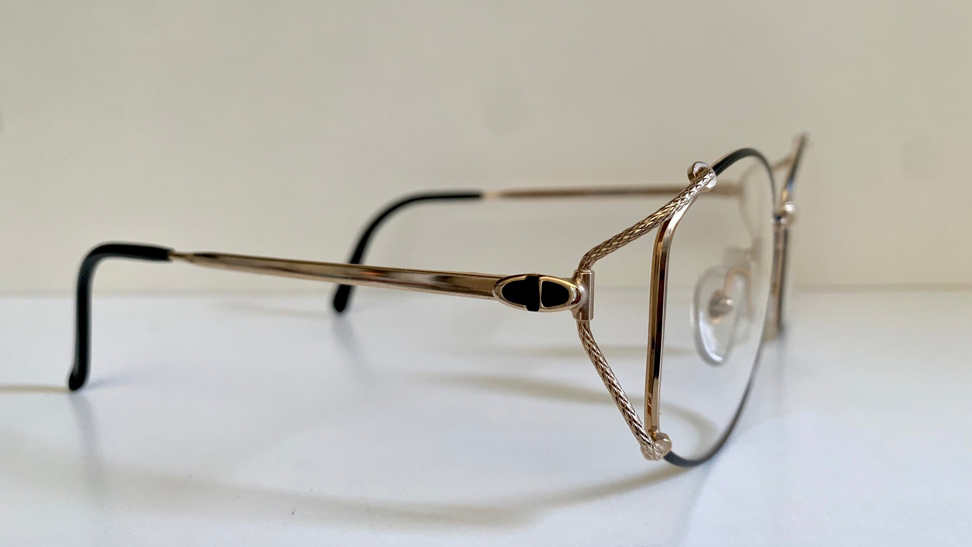 Eyeglasses with a gold frame on a white surface