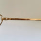 Gold-framed eyeglasses with 'Christian Dior' branding on a light background