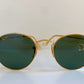 Ray Ban round sunglasses with gold frame and green lenses on a white background