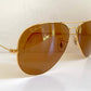 Ray Ban Chromax Gold-framed sunglasses with brown lenses on a white background
