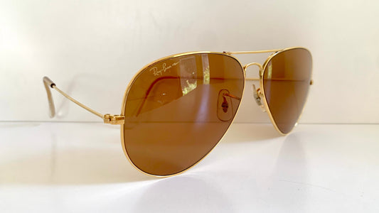 Ray Ban Chromax Gold-framed sunglasses with brown lenses on a white background