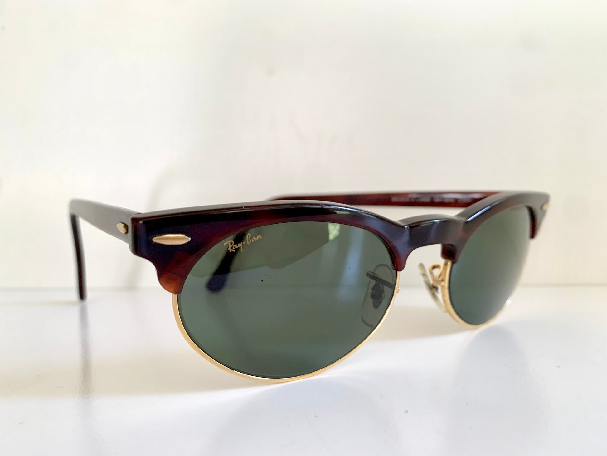 Sunglasses with a tortoiseshell frame and dark lenses on a white background