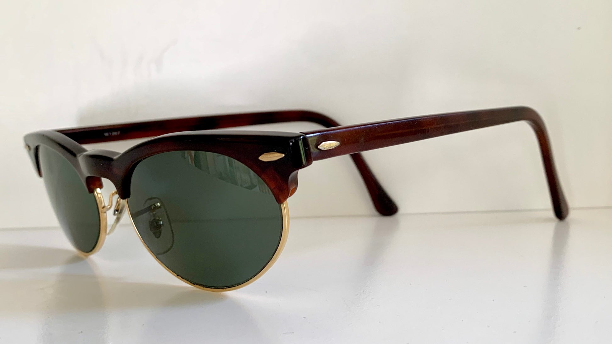 Sunglasses with brown frame and green lenses on a white background