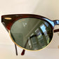 Round sunglasses with a reflective surface on a light background