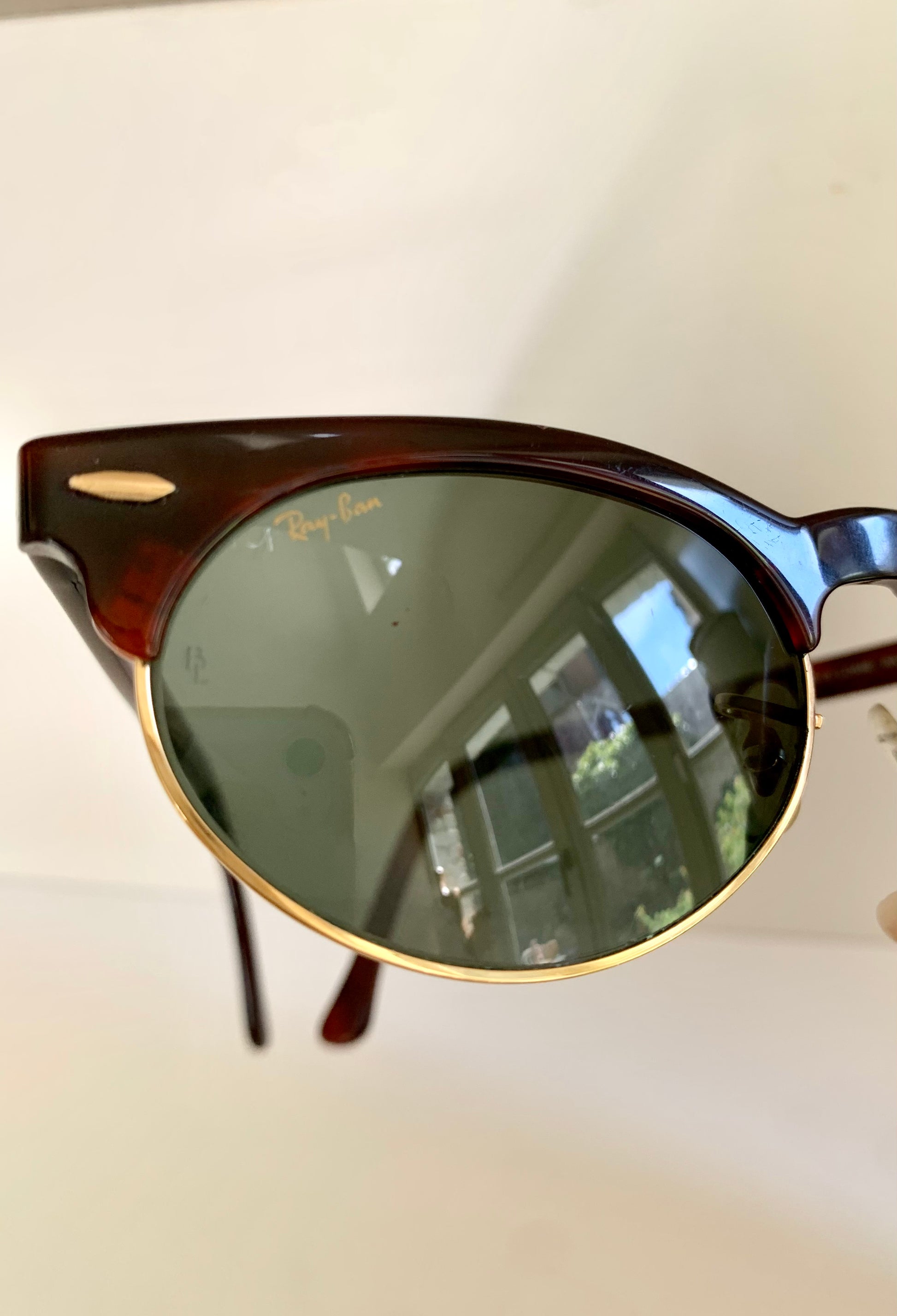 Round sunglasses with a reflective surface on a light background