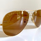 Ray Ban Chromax Aviator sunglasses with gold frame and brown lenses on a white background