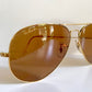 Ray Ban Chromax Gold-framed sunglasses with brown lenses on a white background