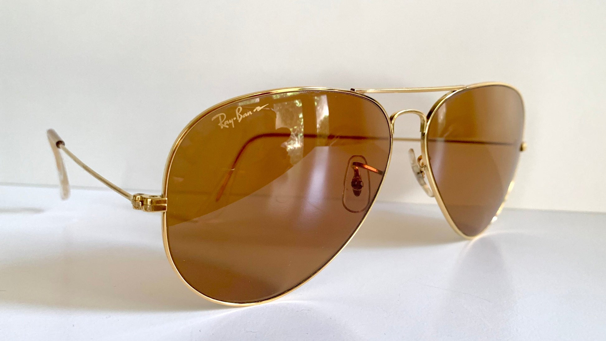 Ray Ban Chromax Gold-framed sunglasses with brown lenses on a white background
