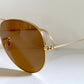 Ray Ban Chromax Gold-framed sunglasses with brown lenses on a white background