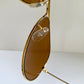 Ray Ban Chromax Gold-framed sunglasses with brown lenses on a white background