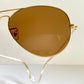 Ray Ban Chromax Gold-framed sunglasses with brown lenses on a white background