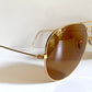 Ray Ban Chromax Gold-framed sunglasses with brown lenses on a white background