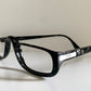 Black eyeglasses on a white surface with a light gray background