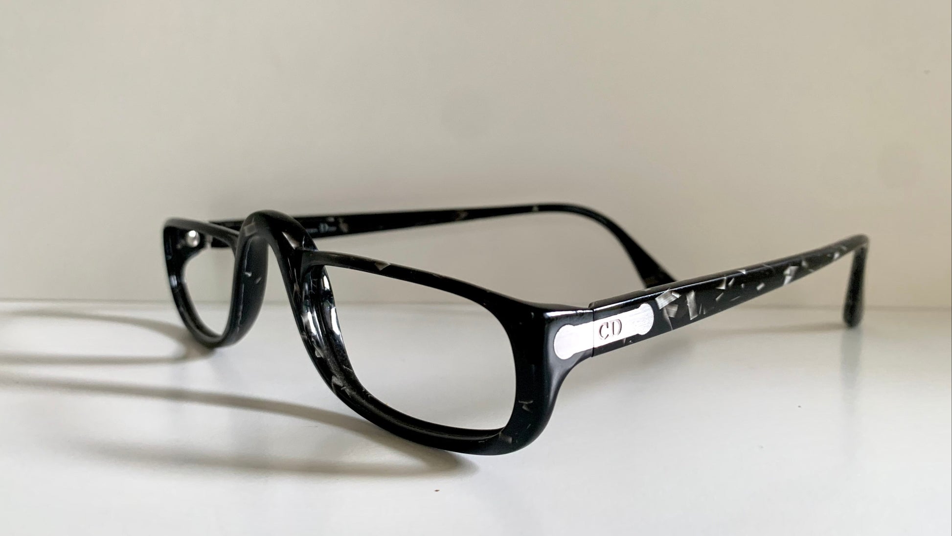 Black eyeglasses on a white surface with a light gray background