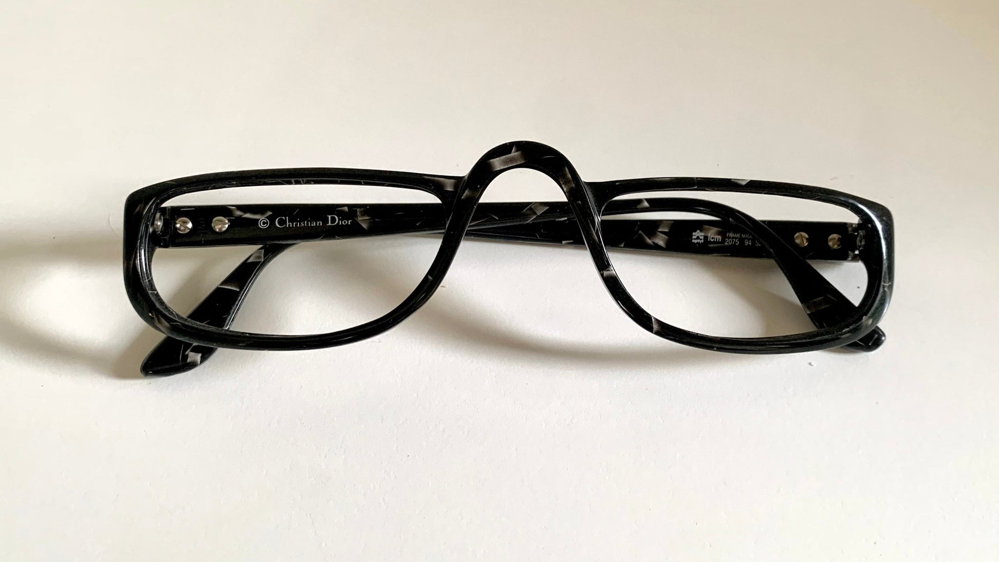 Christian Dior black eyeglasses on a white background