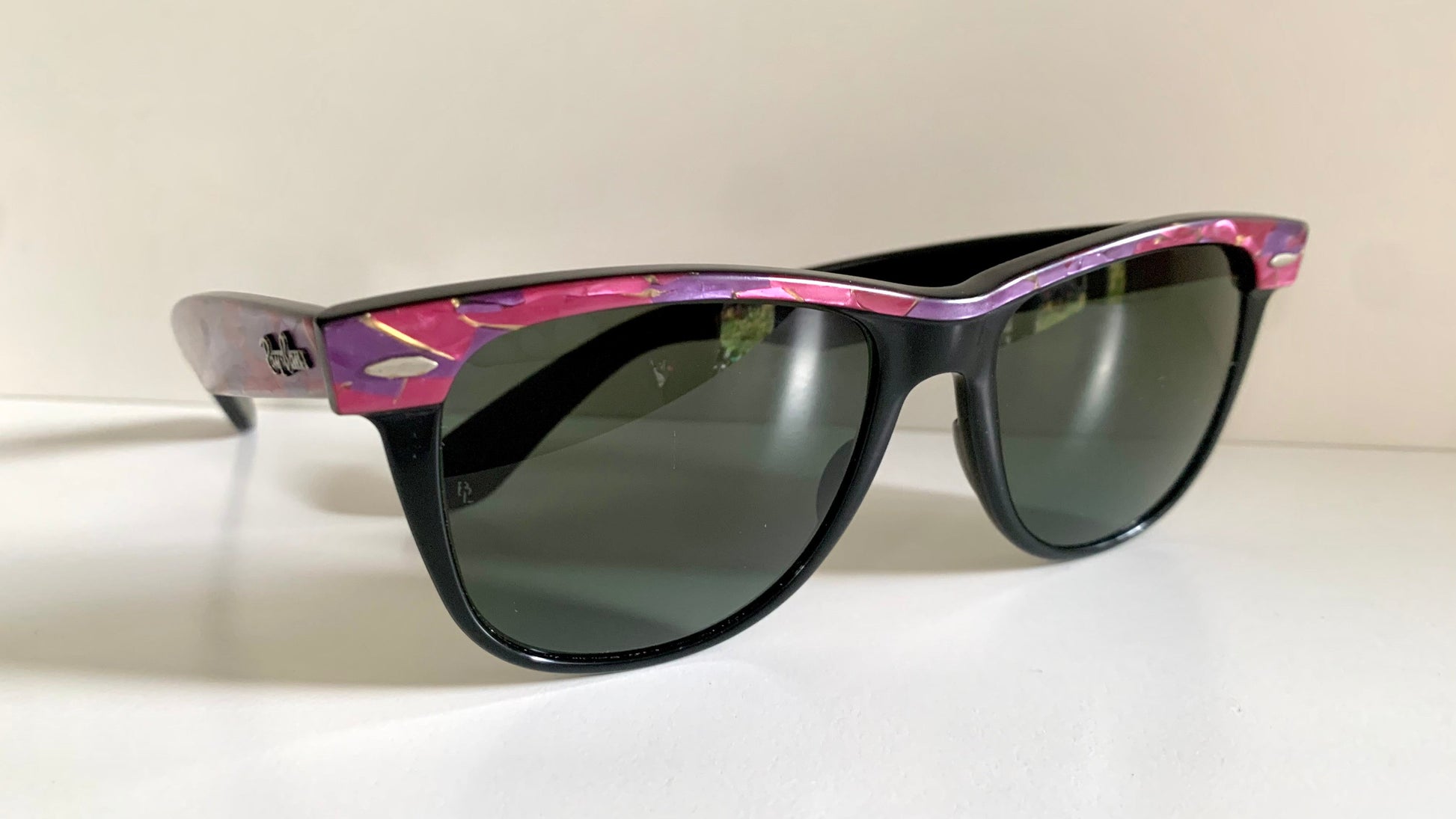 Ray Ban Sreet neat sunglasses with pink mosaice frame on a white surface