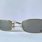 Gold-framed sunglasses with 'Dior' logo on a light gray background