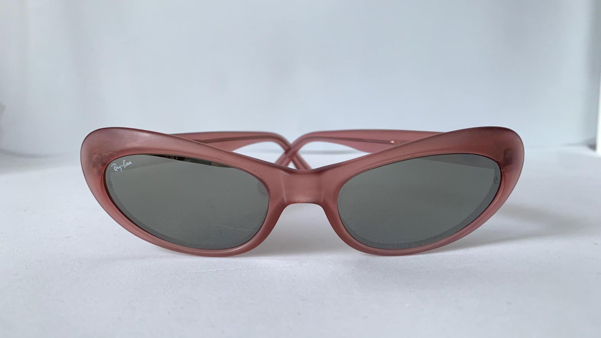 Pink sunglasses with mirrored lenses on a white background
